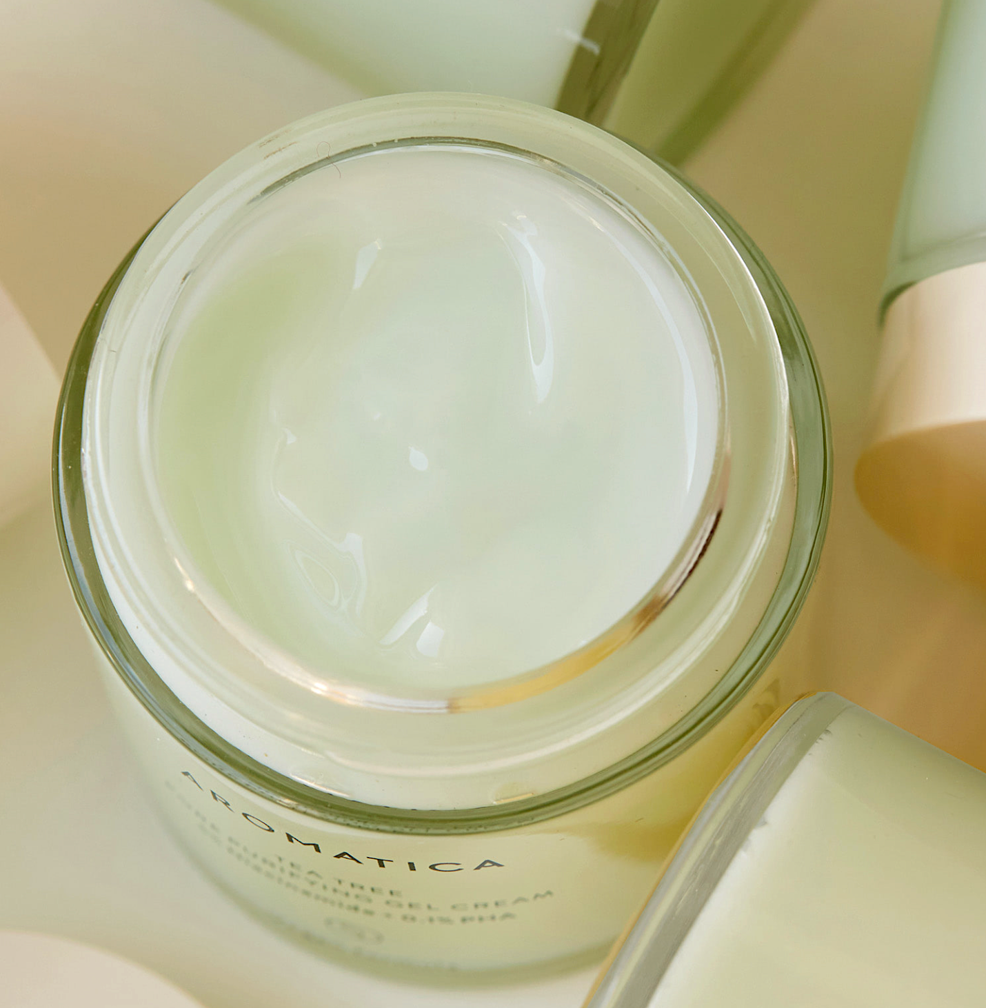 Opened jar of silky and creamy texture in a pale touch of green minty color